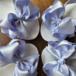 Large blue coloured bows on high wedge heel flip flops