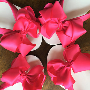 Large hot pink coloured bows on high wedge heel flip flops