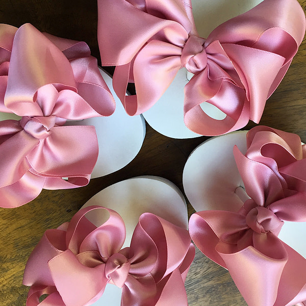 Large dusky pink coloured bows on high wedge heel flip flops
